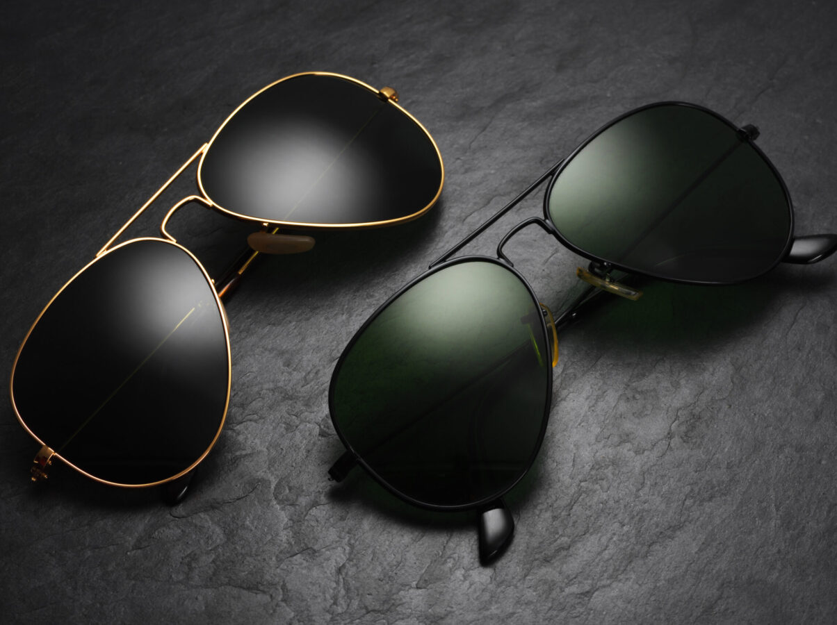 Classic old fashion aviator sunglasses on black slate background. Top view
